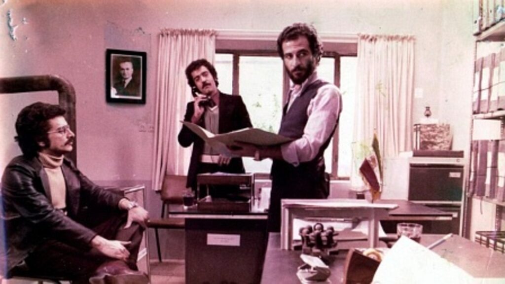 Scene from The Report by Abbas Kiarostami. Three men in an office. Iranian cinema.