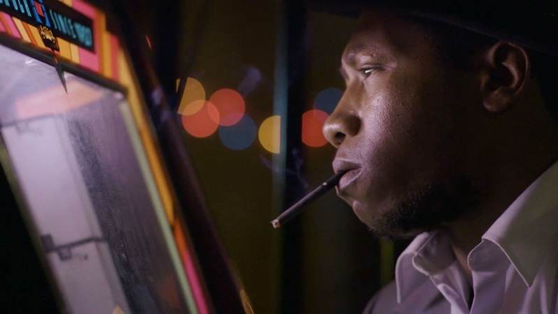 Memphis | Tim Sutton Memphis still from Tim Sutton: Man smokes cigarette by arcade game.