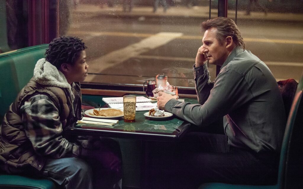 Liam Neeson in A Walk Among the Tombstones. Two people sit in a diner booth.