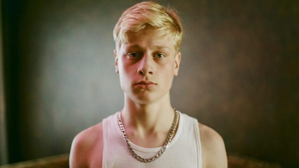 London Film Festival 2014: Young man with blond hair, wearing a white tank top and silver chain.
