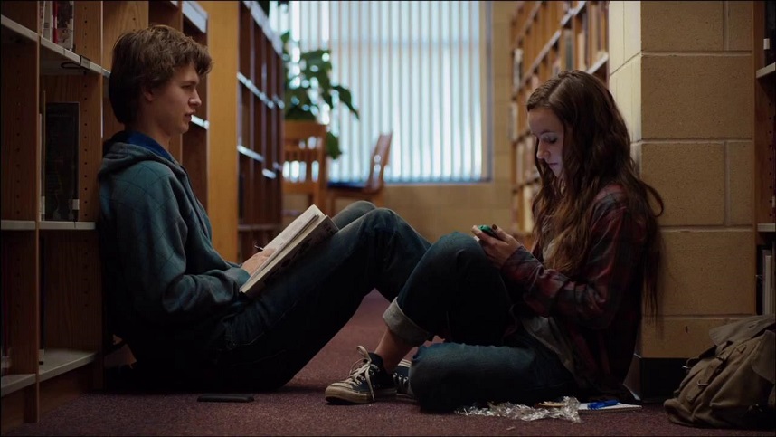 Men, women, children in a library. A boy reads a book, a girl uses a phone. Still from Damien Chazelle's Whiplash.