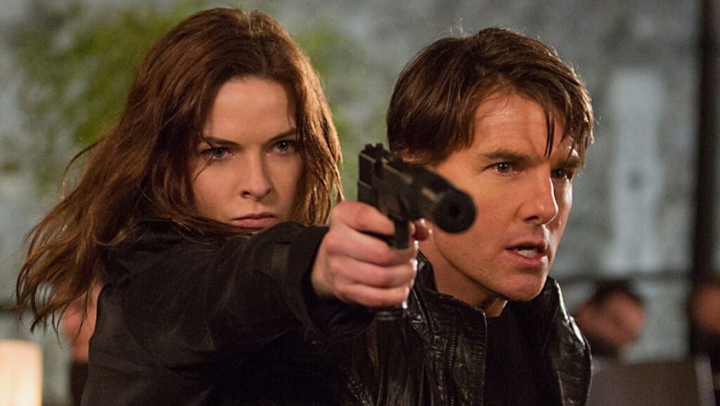 Mission: Impossible - Rogue Nation scene. Ilsa Faust (Rebecca Ferguson) aims a gun alongside Ethan Hunt (Tom Cruise).