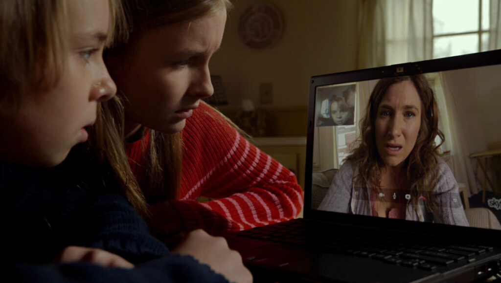 Kids video chatting with mom in The Visit (2015). M. Night Shyamalan horror film. Siblings on laptop.
