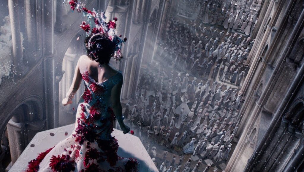 Jupiter Ascending film scene. Woman in floral gown overlooking a crowd. Sci-fi movie.
