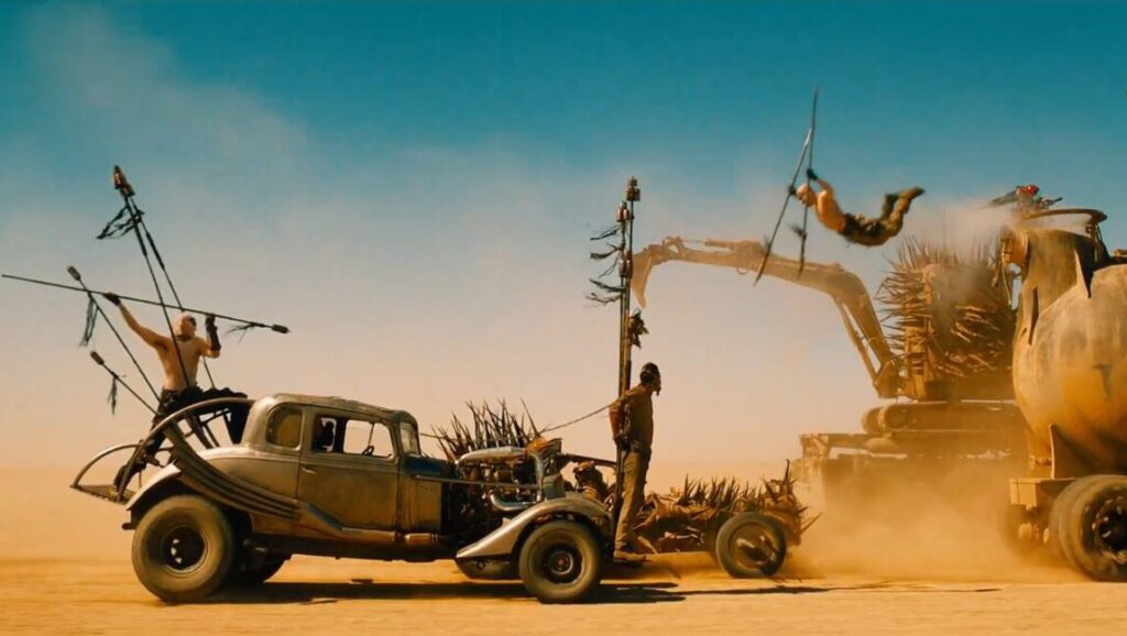 Mad Max: Fury Road | George Miller Mad Max: Fury Road scene. War vehicles in desert, action shot. George Miller film.