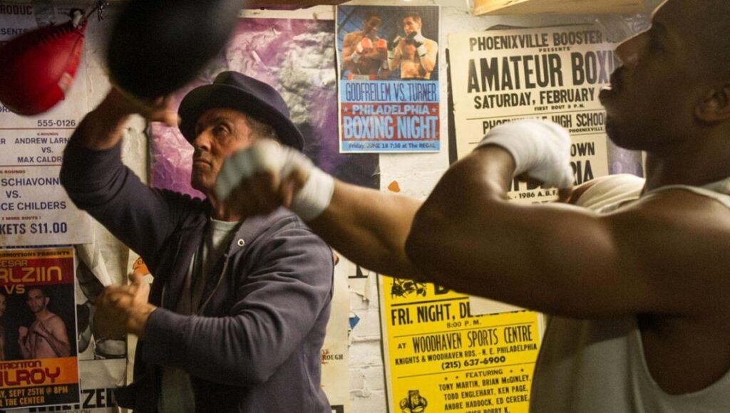 Creed film still: Sylvester Stallone & Michael B. Jordan boxing. Top 2015 films.