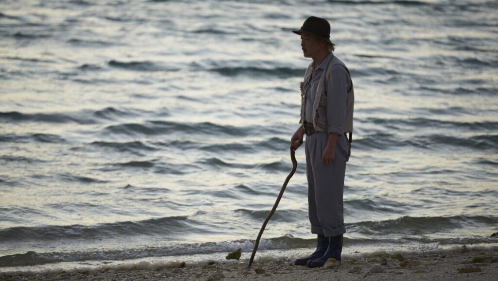Shell Collector film still from Japan Cuts 2016: Man with walking stick on beach.
