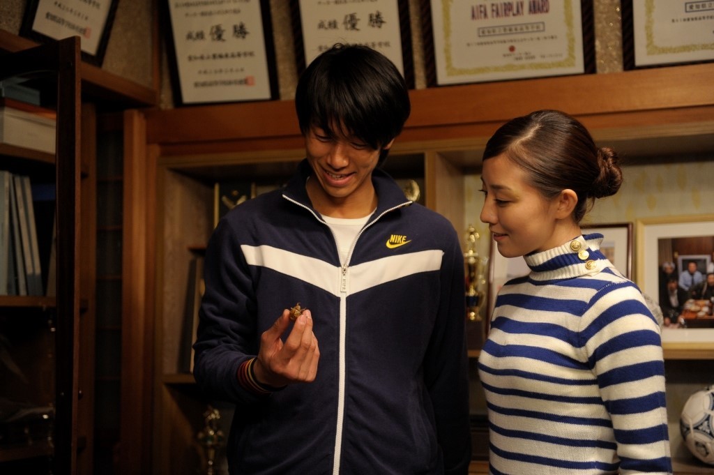 Be Sure to Share | Sion Sono Be Sure to Share movie scene. Man holds object, woman looks on. Sion Sono film.