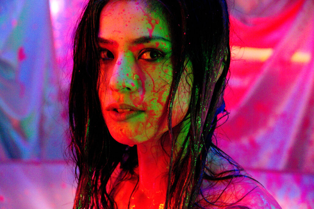 Woman in Guilty of Romance film. Sion Sono movie, vibrant colors, dramatic lighting.