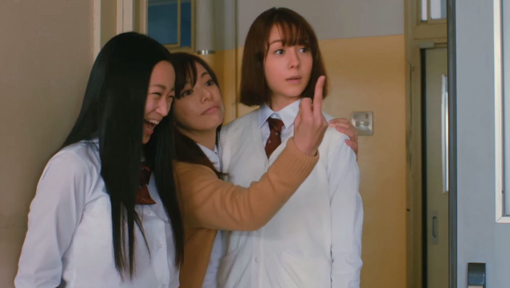 Tag movie still. Three Japanese schoolgirls. One gives the middle finger. Directed by Sion Sono.