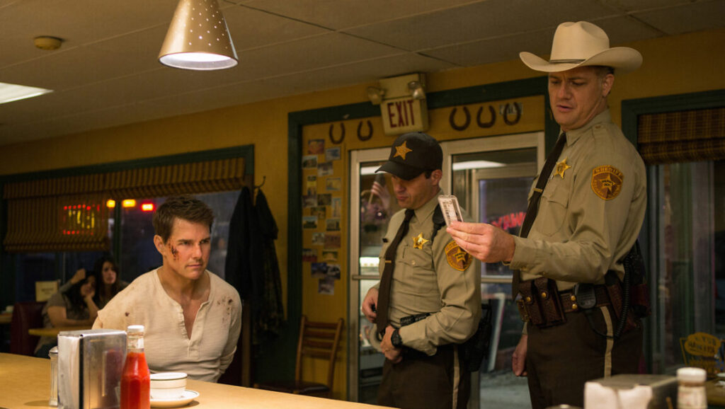 Jack Reacher: Never Go Back | Edward Zwick Jack Reacher: Never Go Back movie scene. Tom Cruise as Reacher in diner, handcuffed, with two sheriffs.