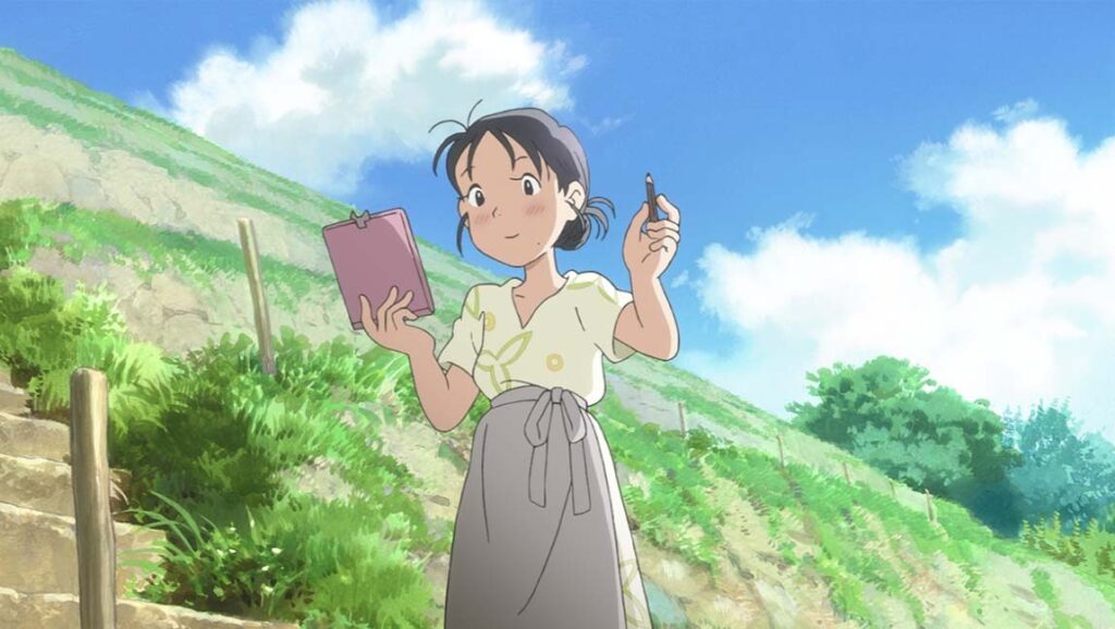 In This Corner of the World anime film still. A young woman holds a pen and sketchbook, set against a hillside and blue sky. Japan Cuts 2017.