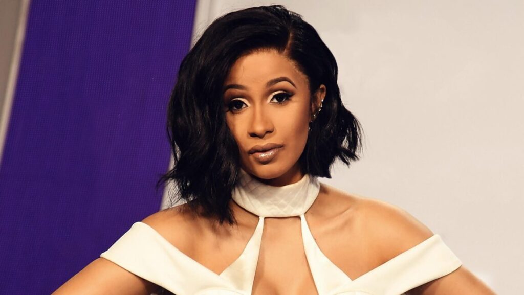 Cardi B album review. Portrait of the rapper with short black hair, wearing a white dress. Halftime albums 2018.