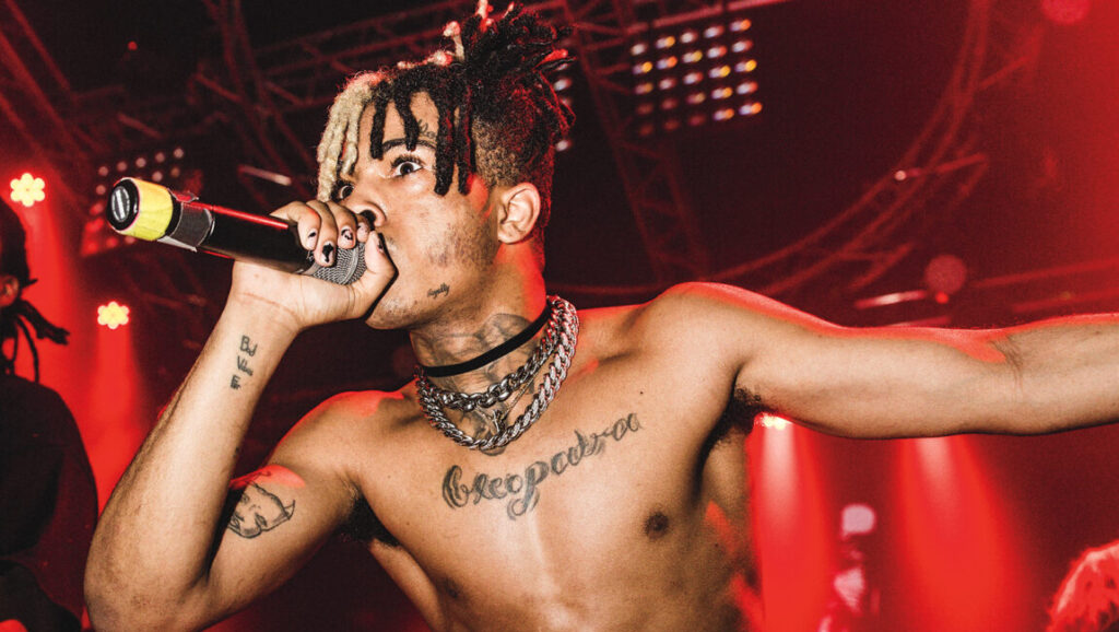 XXXTentacion performing live in 2018. Rapper with tattoos and dreadlocks on stage. Halftime album review.