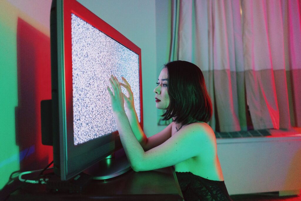 Mitski aesthetic. Woman with hands on TV static screen. Eudaimonia Issue II.
