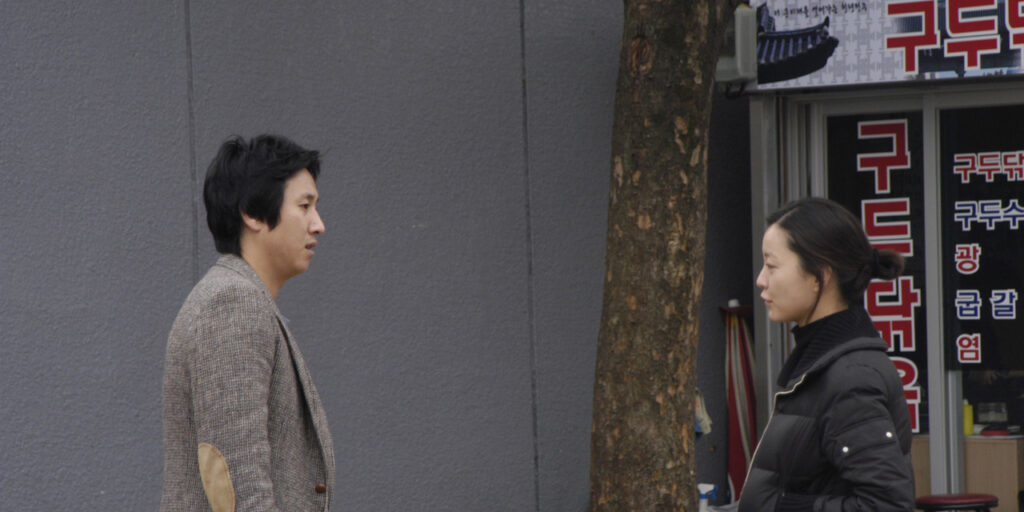 Lost in the Mountains | Hong Sang-soo Lost in the Mountains film still. Man and woman talking on a city street. Hong Sang-soo movie.