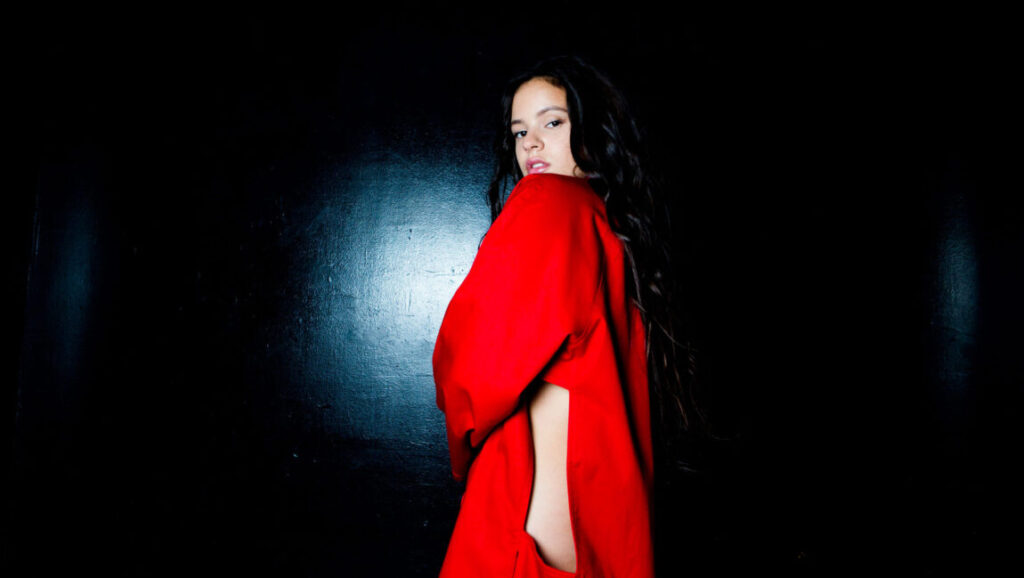 Foreign Correspondent Issue 1: Woman in red dress on black background.