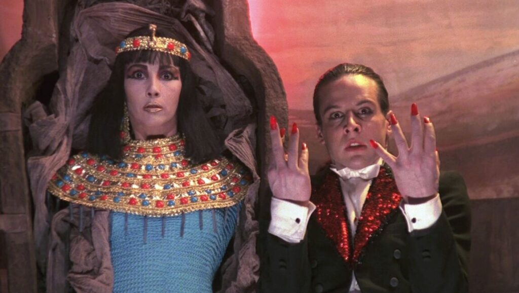 Scene from Alejandro Jodorowsky's Santa Sangre. Woman in Egyptian costume, man with long red fingernails. Classic horror.