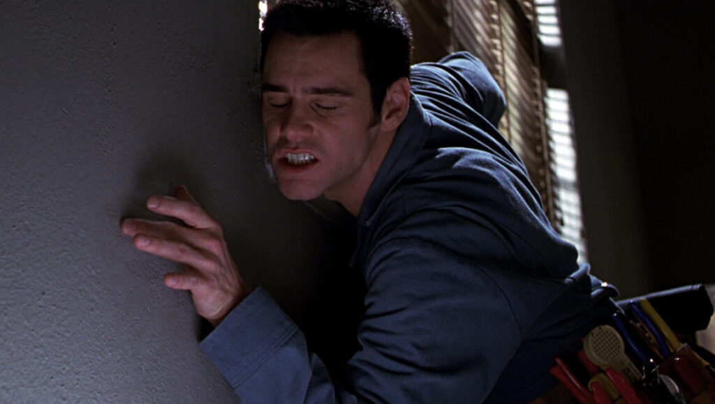 The Cable Guy | Ben Stiller Jim Carrey as The Cable Guy. Carrey is grimacing against a wall.