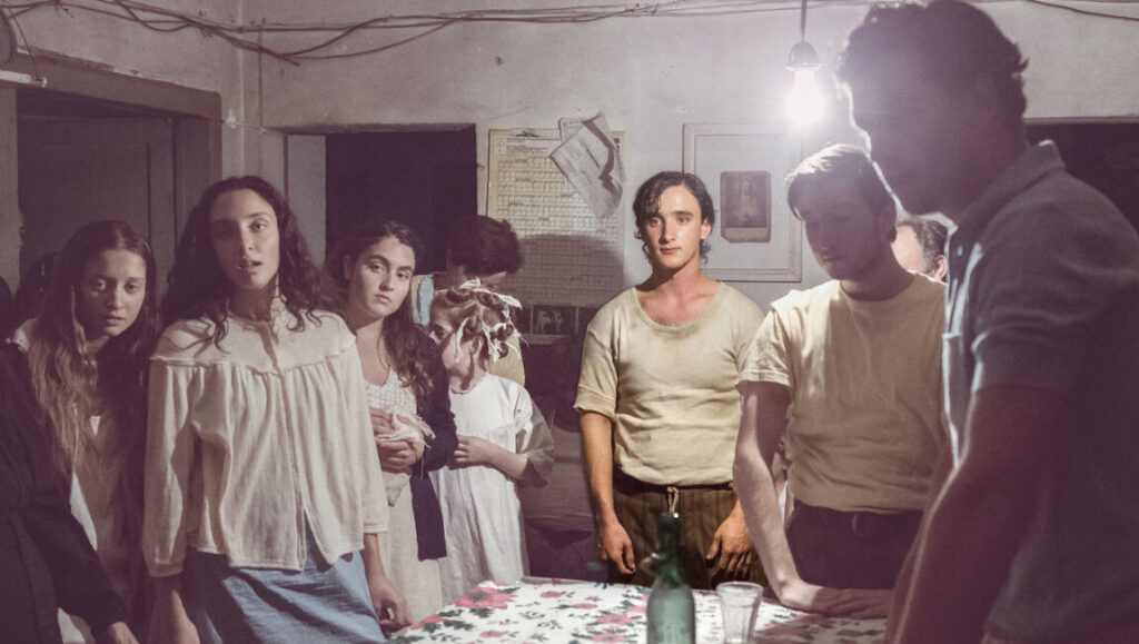 Happy as Lazzaro film still. Group of people indoors, vintage aesthetic. Alice Rohrwacher film.