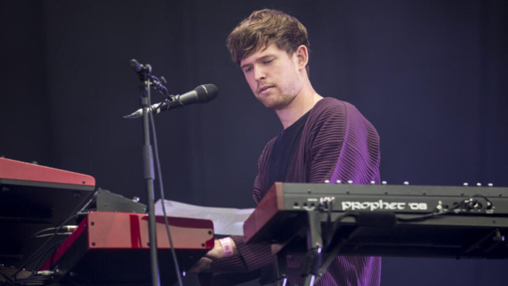 James Blake | Assume Form James Blake performing live. Musician playing keyboard on stage. Assume Form era.