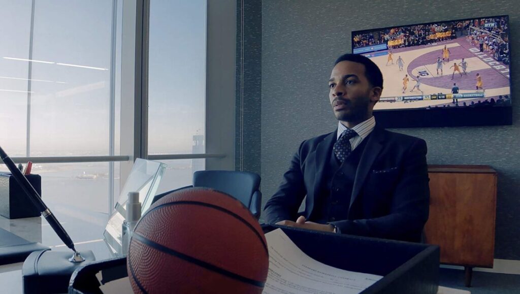 High Flying Bird movie scene. Andre Holland in a suit watches basketball.