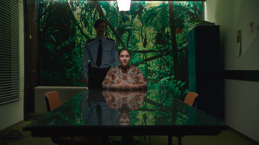 Petrunya at Berlin International Film Festival 2019. Woman at table, officer behind.