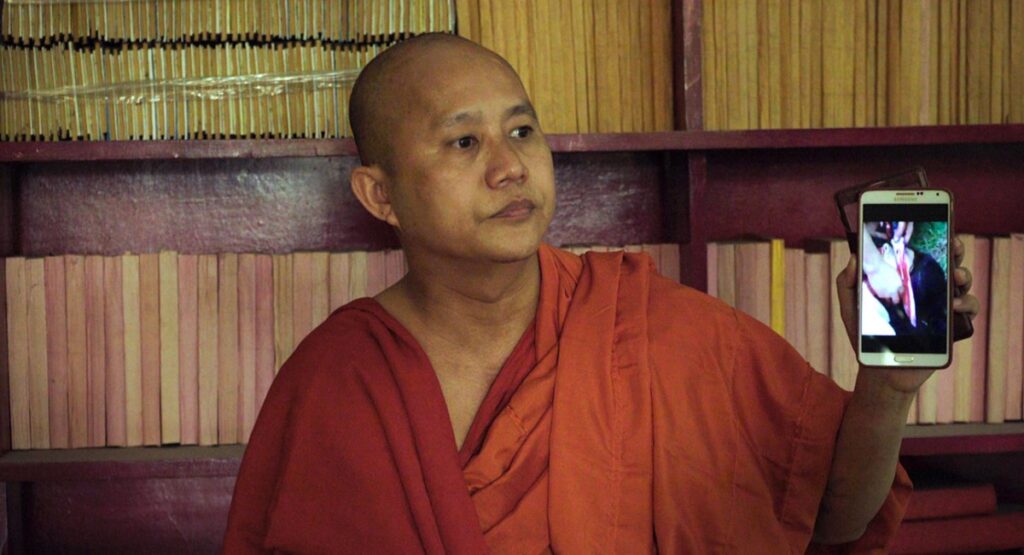 The Venerable W. Monk holding phone with disturbing image. Barbet Schroeder film.