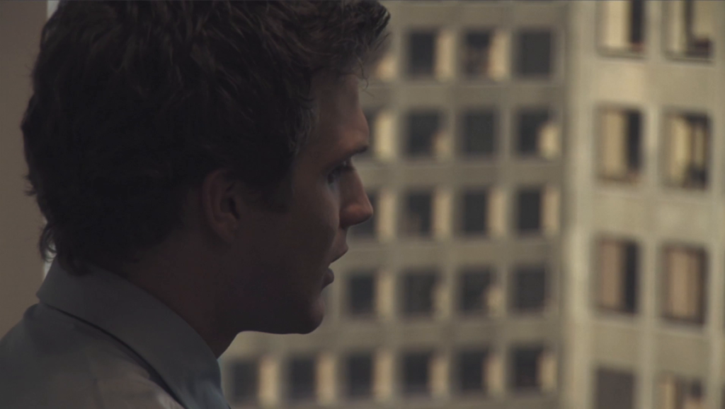 I See You movie review: Actor looking out at city buildings. Thriller film scene.