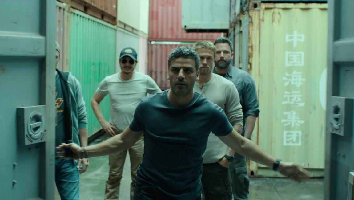 Triple Frontier | JC Chandor Oscar Isaac in Triple Frontier. Cast members stand in front of shipping containers. JC Chandor film.