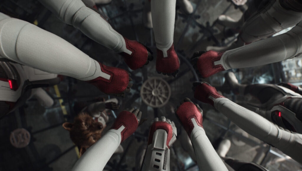 Avengers: Endgame | Joe & Anthony Russo Avengers: Endgame team huddle. The Russo brothers direct the Marvel superhero team in matching white suits with red accents.