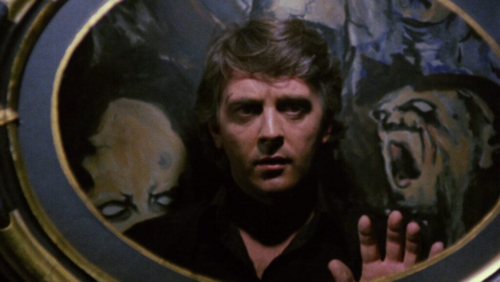 Climax movie still. Man framed by two horror figures. Dark, suspenseful film scene.