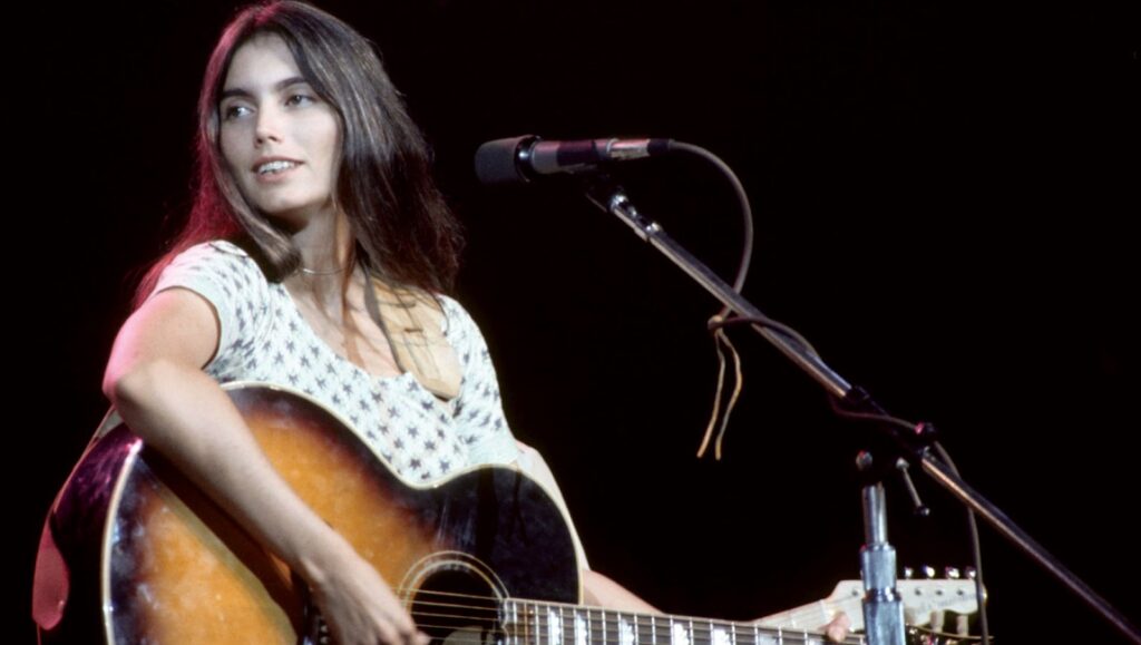 Emmylou Harris | Roses in the Snow Emmylou Harris performing Roses in the Snow with an acoustic guitar at a concert.