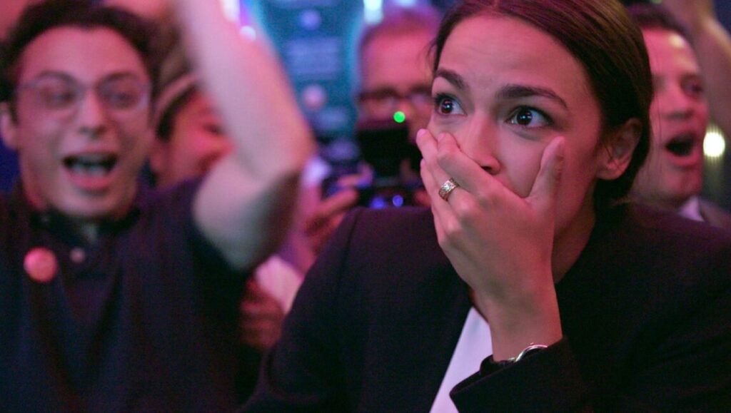 Alexandria Ocasio-Cortez reacts to election results in Knock Down the House. Supporters celebrate.