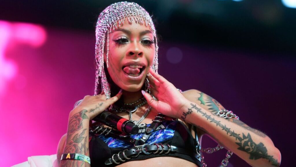 Rapper Rico Nasty performing live. Tattoos, silver headpiece, and microphone. What Would Meek Do? music.