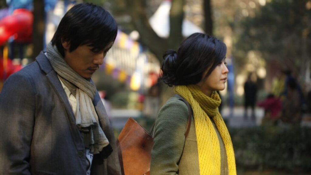 Lou Ye's Mystery film still. A man and woman stand outdoors, both wearing scarves.
