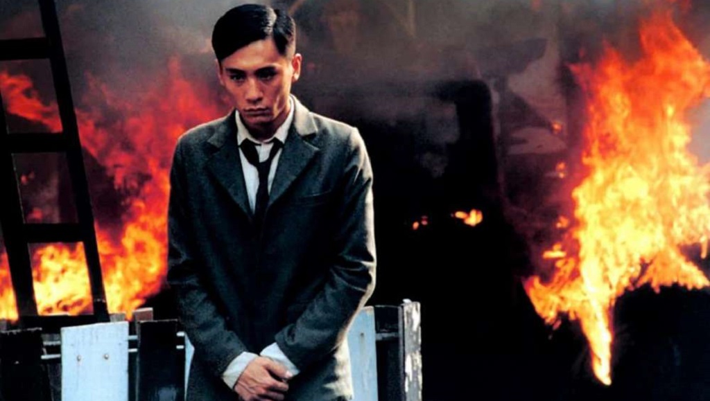 Purple Butterfly | Lou Ye Tony Leung in Purple Butterfly movie. Man in suit with fire background. Lou Ye film.