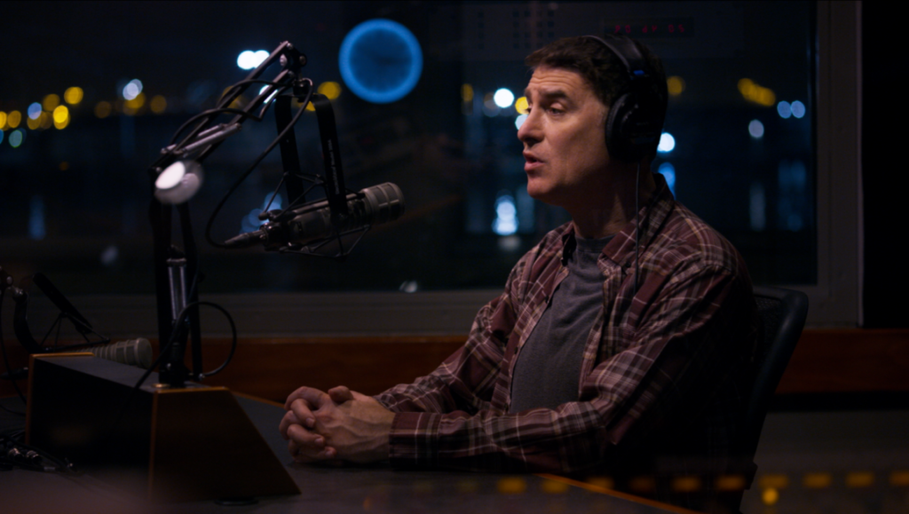 Jeremy Saville recording Loqueesha podcast. Man with headphones at microphone.