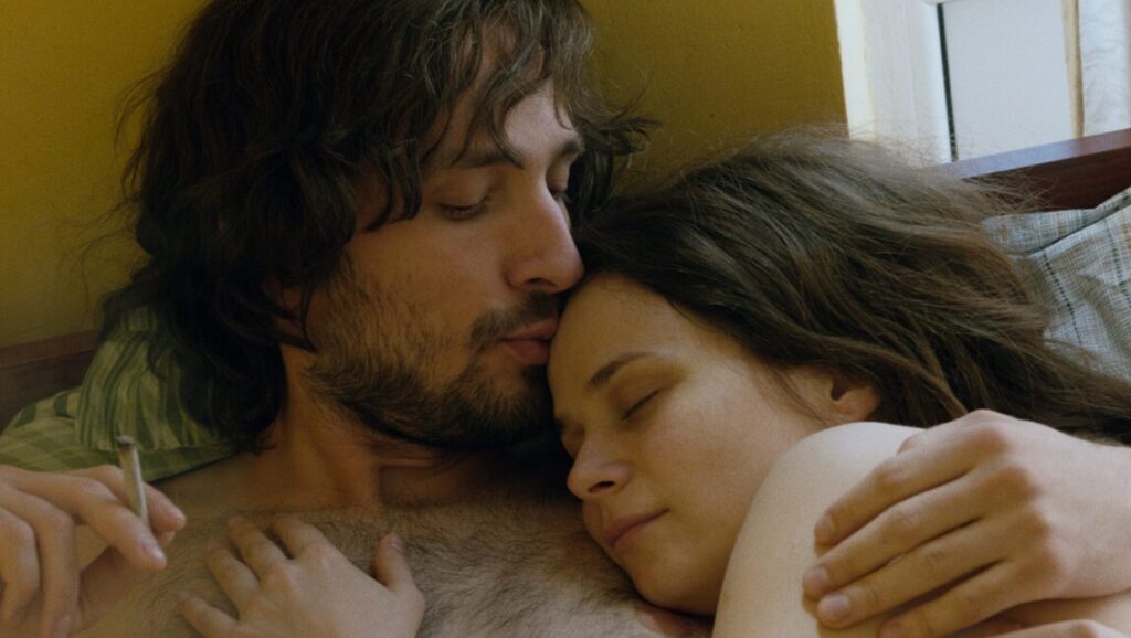 Ana, Mon Amour | Calin Peter Netzer Ana, Mon Amour film still. Man kissing woman's forehead. Couple embracing in bed. Calin Peter Netzer film.