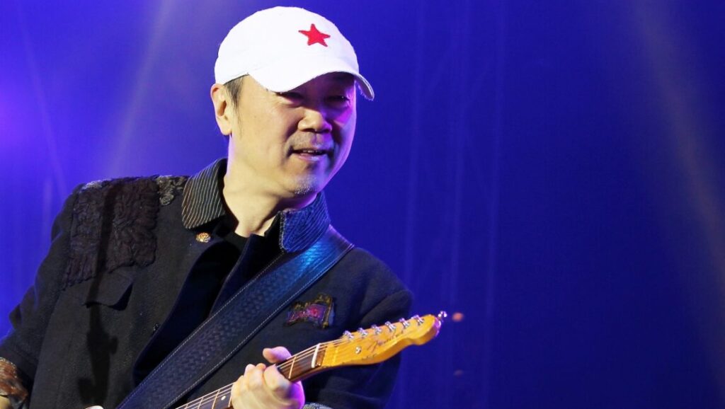 Cui Jian, the Chinese rock musician, performs Frozen Light with a guitar and a white cap with a red star.