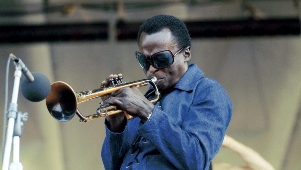 Miles Davis performs Bitches Brew on trumpet. Jazz music legend in concert.
