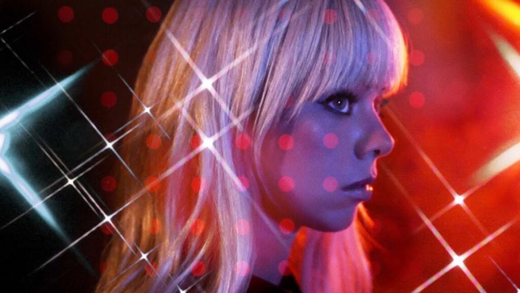Chromatics | Closer to Grey Chromatics' Closer to Grey album art. Woman with blonde hair and bangs, red and blue lighting effects.
