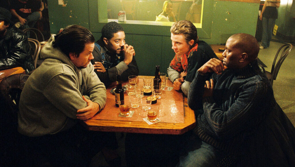 Summer Blockbuster!?! | Episode 104: Four Brothers Four Brothers movie scene. Mark Wahlberg and cast sit at a table with drinks. Summer Blockbuster film.