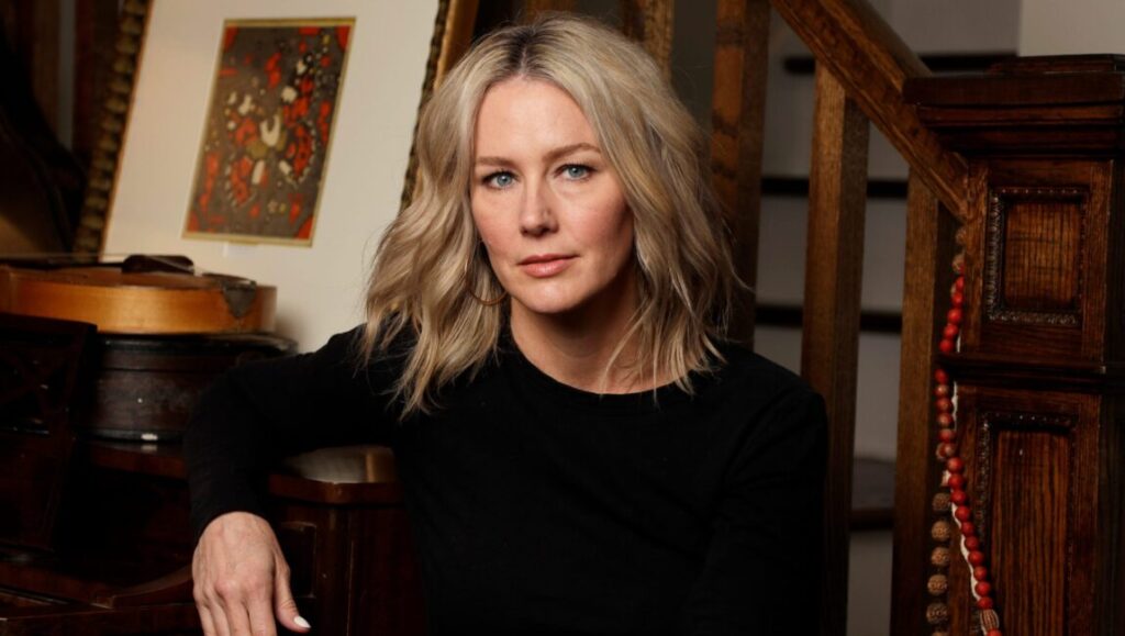 Allison Moorer portrait. Singer-songwriter with blonde hair in black top. Rooted & Restless December.