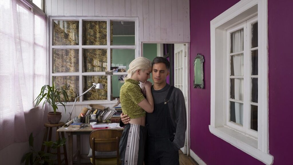 Neighboring Scenes 2020: A scene with a couple embracing indoors. Interior design includes a purple wall and a window.