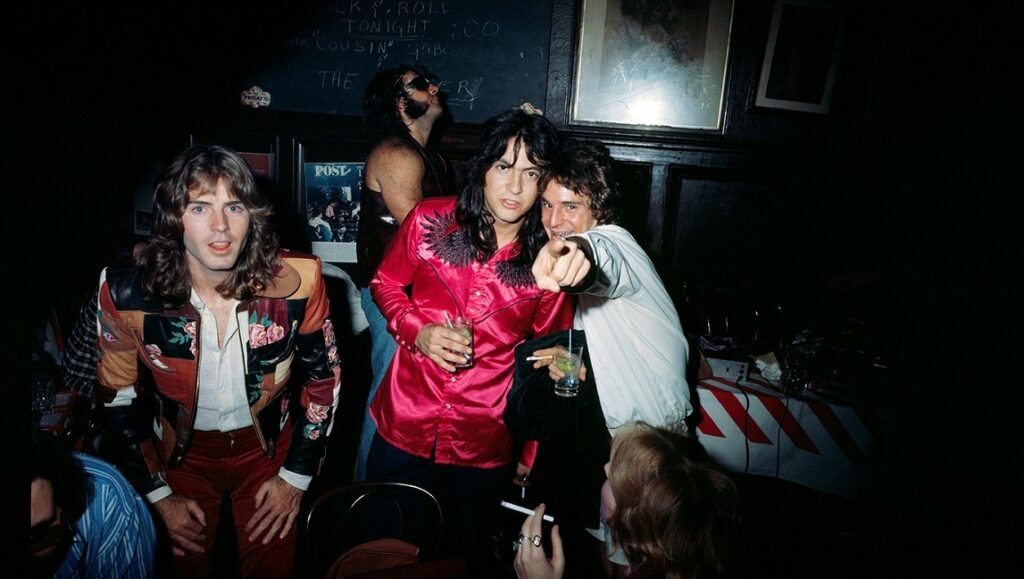 Big Star's Radio City era: Band members at a bar, possibly celebrating. 70s rock and roll vibe.