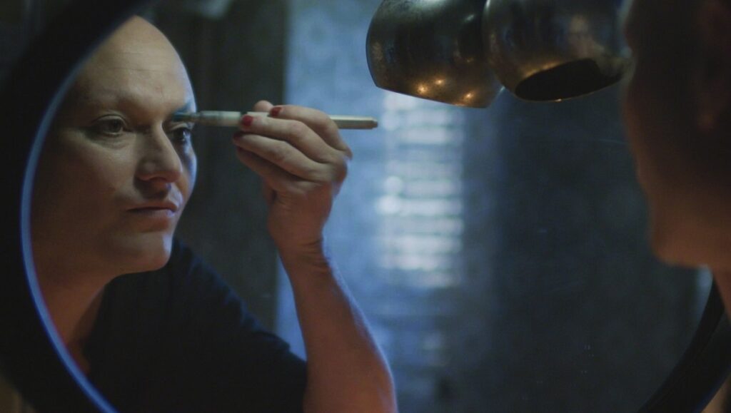 The House of Love | Luca Ferri Reflection in mirror of person applying makeup. The House of Love by Luca Ferri.