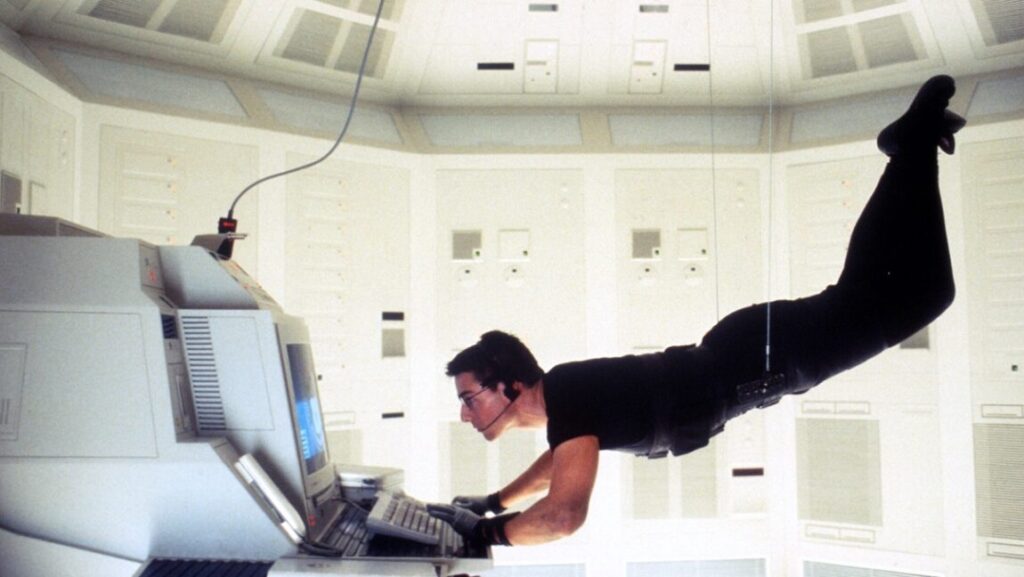Tom Cruise in Mission: Impossible. Brian De Palma film scene of Cruise suspended, hacking a computer.