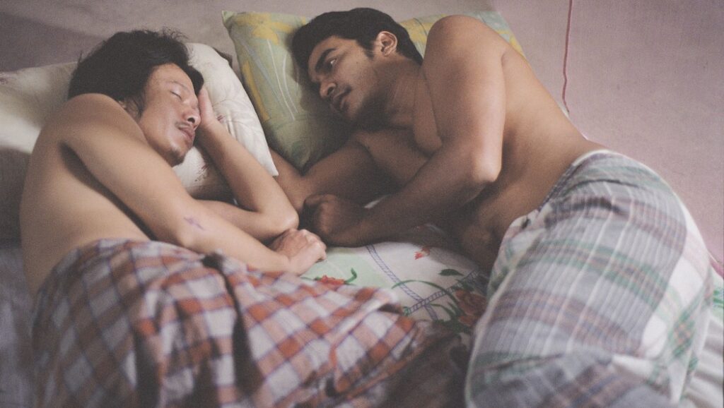 I Don't Want to Sleep Alone film still: Two shirtless men lying in bed together. Tsai Ming-liang movie.