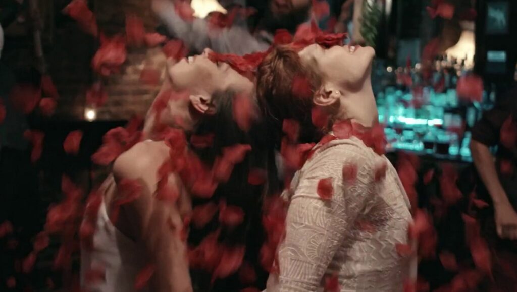 Aviva | Boaz Yakin Aviva movie scene: Two dancers under falling rose petals, heads tilted back.